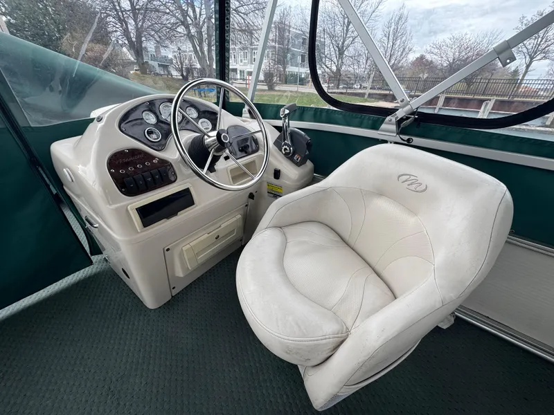 Slide: The Image of 2007 Manitou Legacy boat interior with steering wheel and captain's chair. - 7