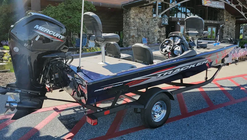 Slide: The Image of 2021 Tracker Pro Team 175 TF boat with Mercury engine, parked outdoors. - 2