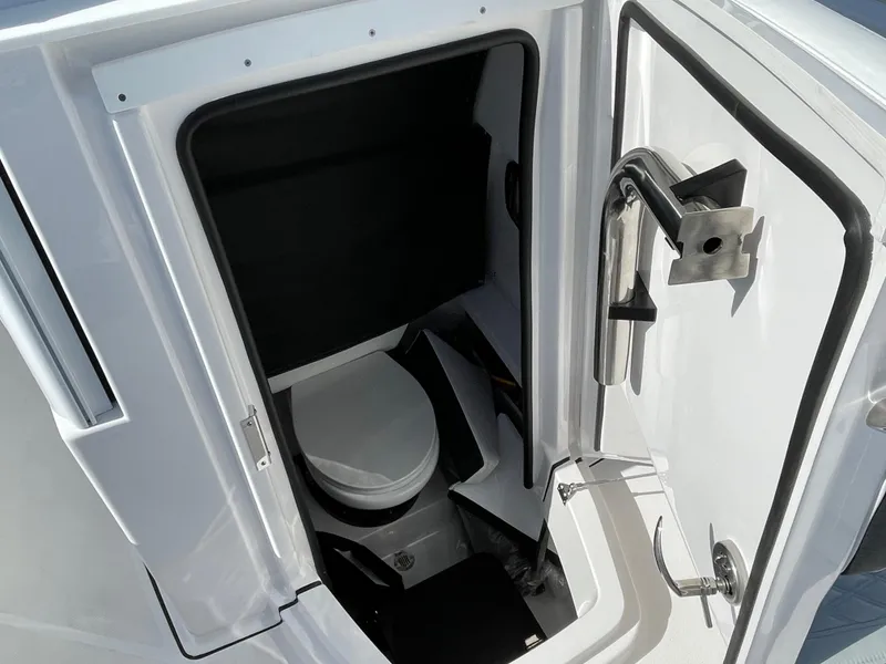 Slide: The Image of 2025 Blackfin 252CC boat interior with compact marine toilet and stainless steel handle. - 14