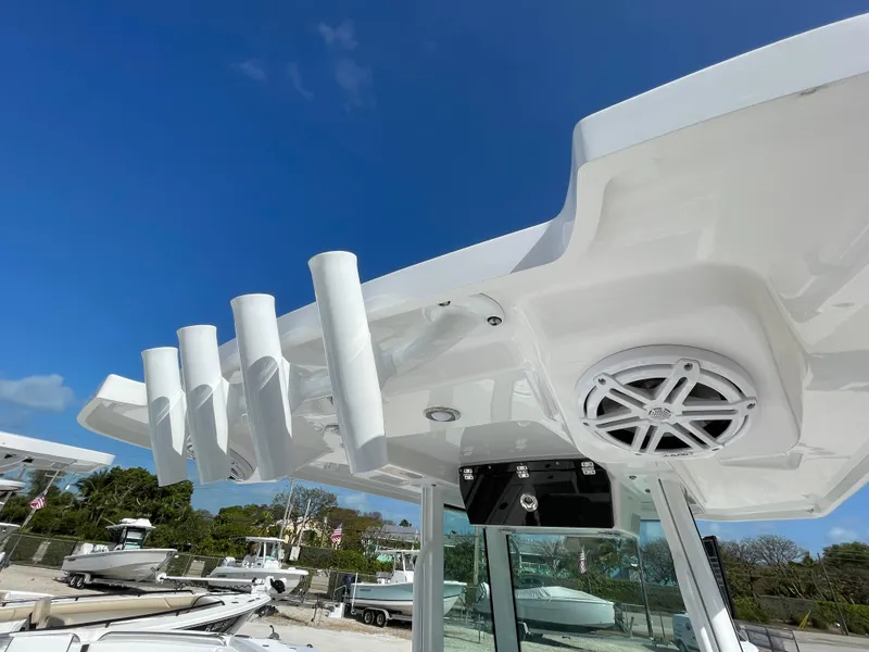 Slide: The Image of 2025 Blackfin 252CC boat with rod holders and speaker, under clear blue sky. - 17