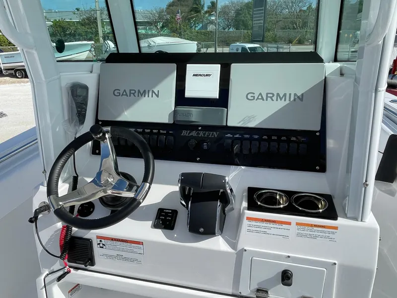 Slide: The Image of 2025 Blackfin 252CC boat dashboard with Garmin displays and steering wheel. - 18