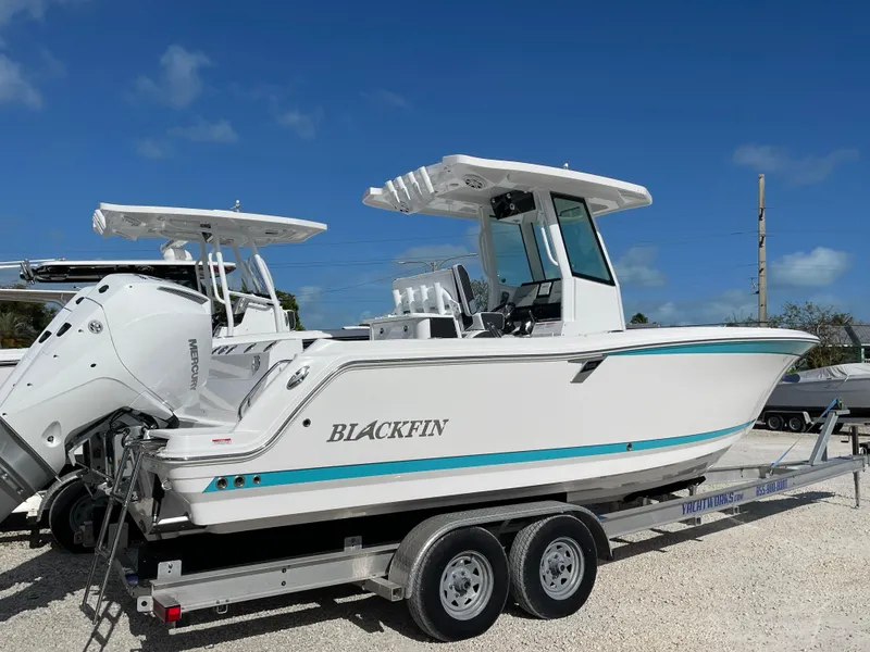 Slide: The Image of 2025 Blackfin 252CC boat on trailer under clear blue sky. - 2