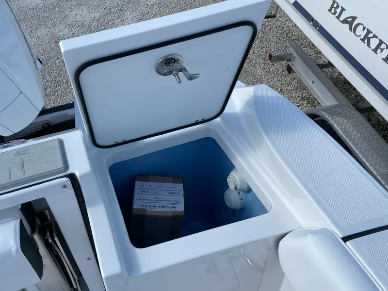 Slide: The Image of 2025 Blackfin 252CC boat storage compartment with open lid and visible contents. - 30