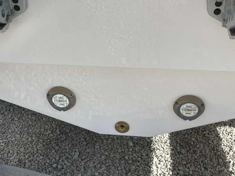 Slide: The Image of 2025 Blackfin 252CC boat hull with underwater lights on gravel surface. - 35