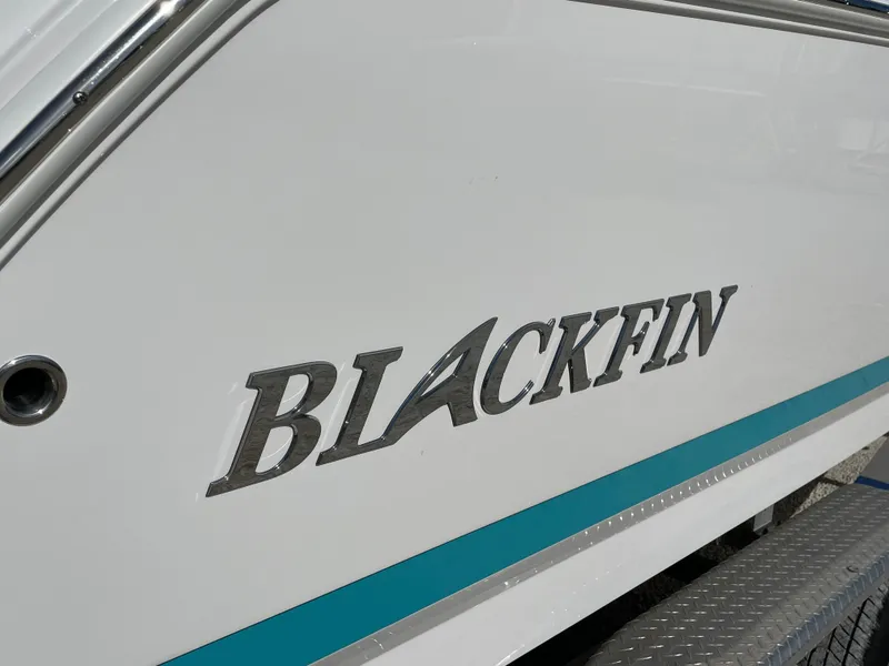 Slide: The Image of 2025 Blackfin 252CC boat logo on white hull with teal accent stripe. - 4