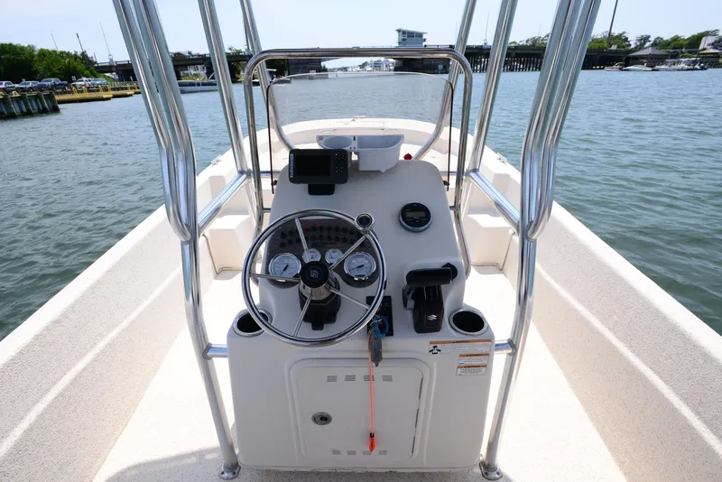 Slide: The Image of 2018 Carolina Skiff 218 DLV boat console with steering wheel on calm water. - 14