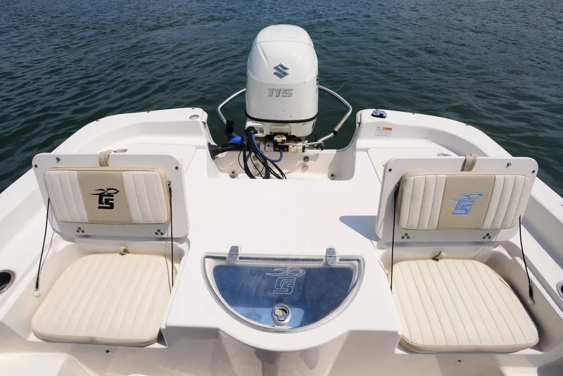 Slide: The Image of 2018 Carolina Skiff 218 DLV boat interior with Suzuki outboard motor on water. - 18