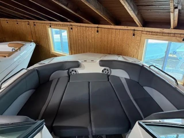 Slide: The Image of 2023 NauticStar 203 DC boat interior with cushioned seating in a wooden boathouse. - 10