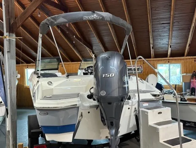 Slide: The Image of 2023 NauticStar 203 DC boat with Yamaha 150 engine in a wooden boathouse. - 3