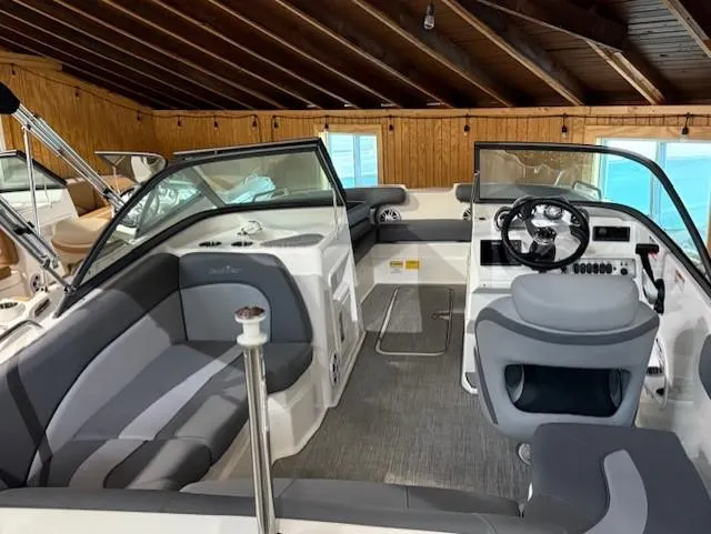 Slide: The Image of 2023 NauticStar 203 DC boat interior with gray seating and modern dashboard. - 5
