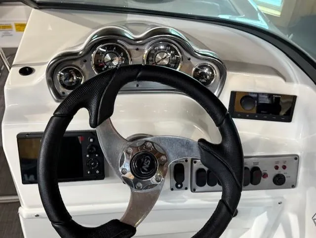 Slide: The Image of 2023 NauticStar 203 DC boat dashboard with steering wheel and instrument panel. - 6