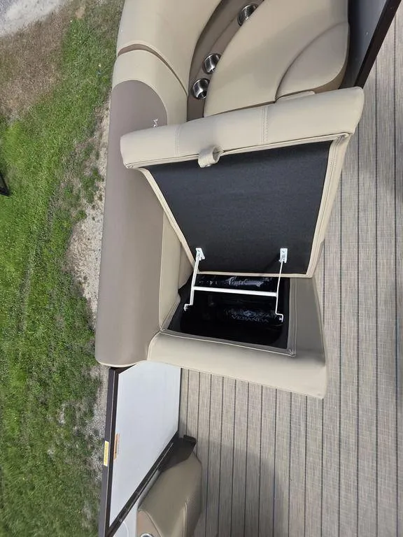 Slide: The Image of Open storage compartment on 2025 Veranda VR22RC Tri-Toon boat with beige seating. - 12