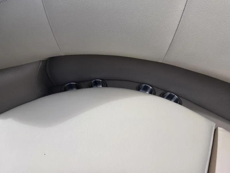 Slide: The Image of 2025 Veranda VR22RC Tri-Toon boat interior with beige leather seating and integrated cup holders. - 18