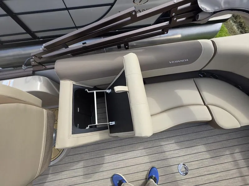 Slide: The Image of 2025 Veranda VR22RC Tri-Toon interior with beige seating and storage compartment. - 20