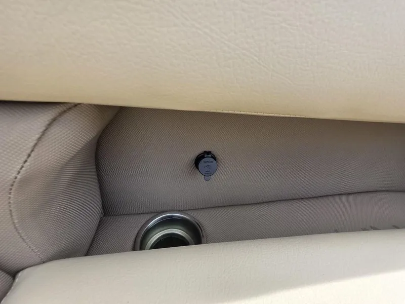 Slide: The Image of 2025 Veranda VR22RC Tri-Toon interior detail with beige upholstery and power outlet. - 37