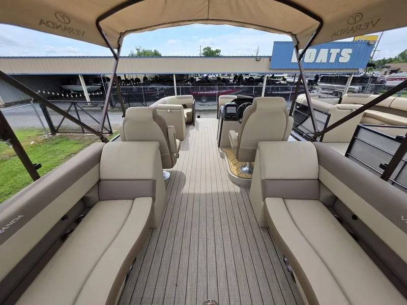 Slide: The Image of 2025 Veranda VR22RC Tri-Toon boat interior with spacious seating and helm under canopy. - 45