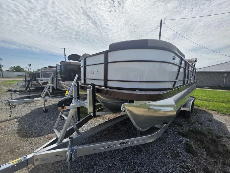Slide: The Image of 2025 Veranda VR22RC Tri-Toon boat on trailer, parked outdoors under cloudy sky. - 9