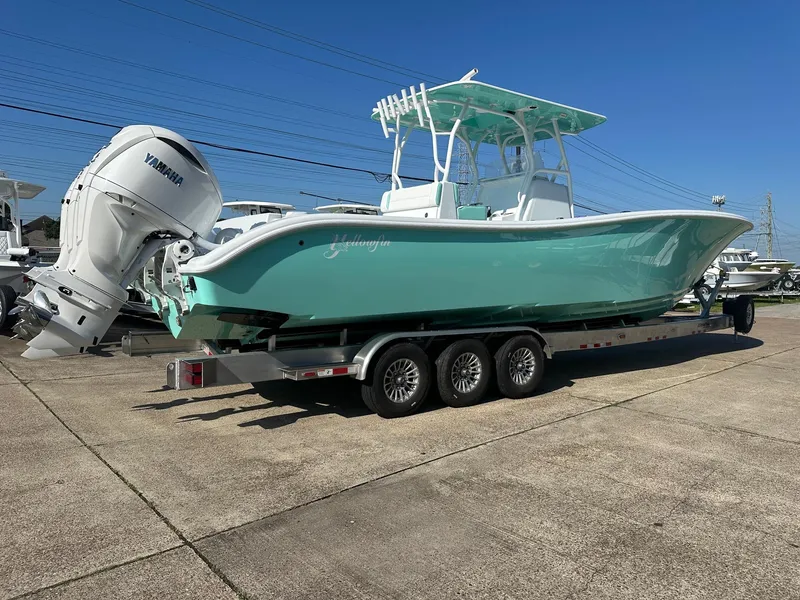 Slide: The Image of 2024 Yellowfin 36 Offshore boat on trailer, featuring Yamaha engines, in a marina setting. - 1