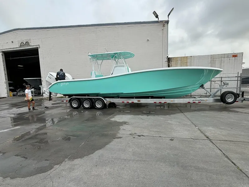 Slide: The Image of 2024 Yellowfin 36 Offshore boat on trailer outside industrial building. - 2