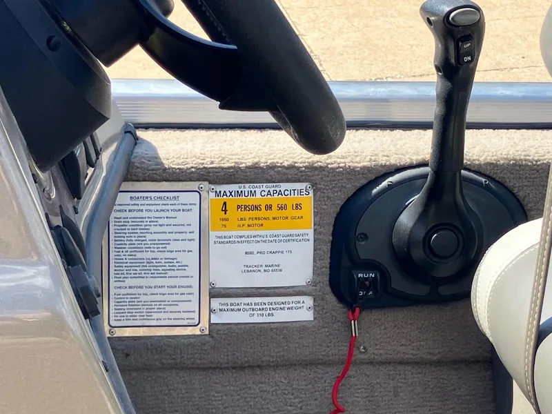 Slide: The Image of 2007 Tracker Pro Crappie 175 boat controls and capacity label, showing steering wheel and throttle. - 10