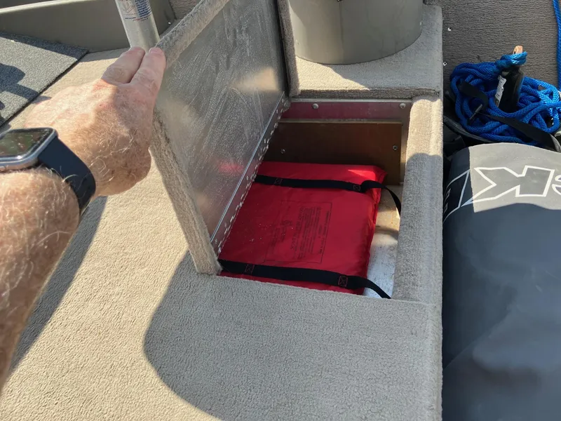 Slide: The Image of 2007 Tracker Pro Crappie 175 boat storage compartment with red life jacket inside. - 13