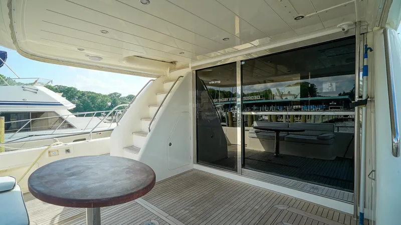 Slide: The Image of Outdoor deck of 2002 Viking Princess 68 yacht with table and stairs. - 11