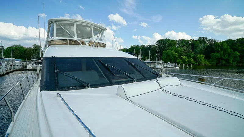 Slide: The Image of Luxury 2002 Viking Princess 68 yacht docked by a scenic riverside marina. - 16