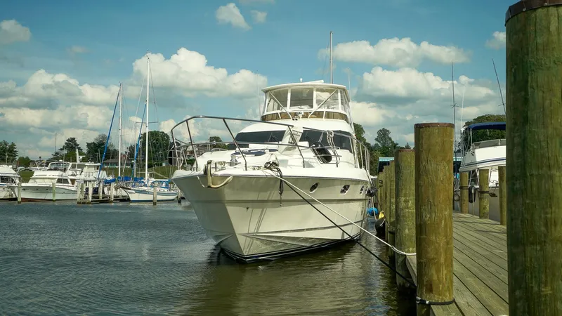 Slide: The Image of Luxury 2002 Viking Princess 68 yacht docked at marina under blue sky. - 2