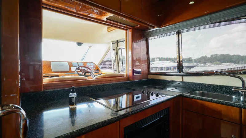 Slide: The Image of Luxurious kitchen interior of 2002 Viking Princess 68 yacht with sleek countertops and scenic window view. - 23
