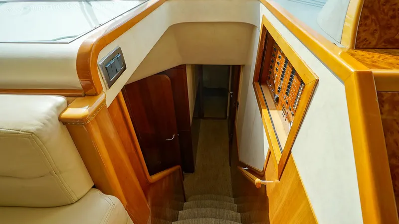 Slide: The Image of Interior staircase of 2002 Viking Princess 68 yacht, featuring wood paneling and carpeted steps. - 33