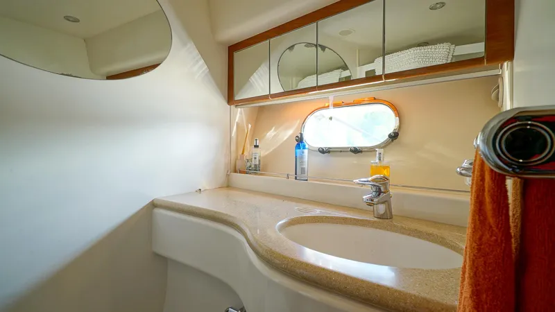 Slide: The Image of Luxurious bathroom in 2002 Viking Princess 68 yacht with modern fixtures and oval window. - 36