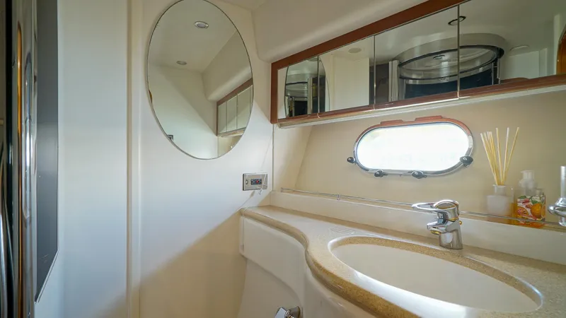 Slide: The Image of Luxurious bathroom in 2002 Viking Princess 68 yacht with oval mirror and porthole window. - 38