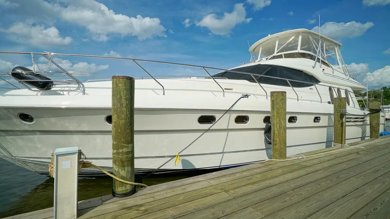 Slide: The Image of Luxury 2002 Viking Princess 68 yacht docked under a clear blue sky. - 4