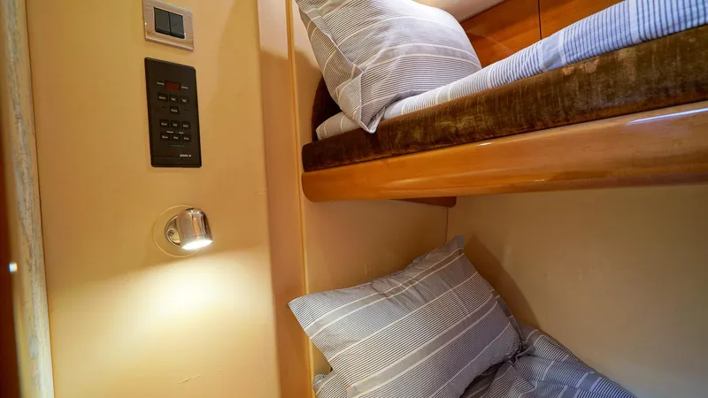 Slide: The Image of Bunk beds in 2002 Viking Princess 68 yacht cabin with striped bedding and wall-mounted light. - 42