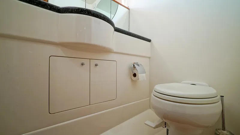 Slide: The Image of Bathroom interior of 2002 Viking Princess 68 yacht, featuring toilet and vanity. - 43