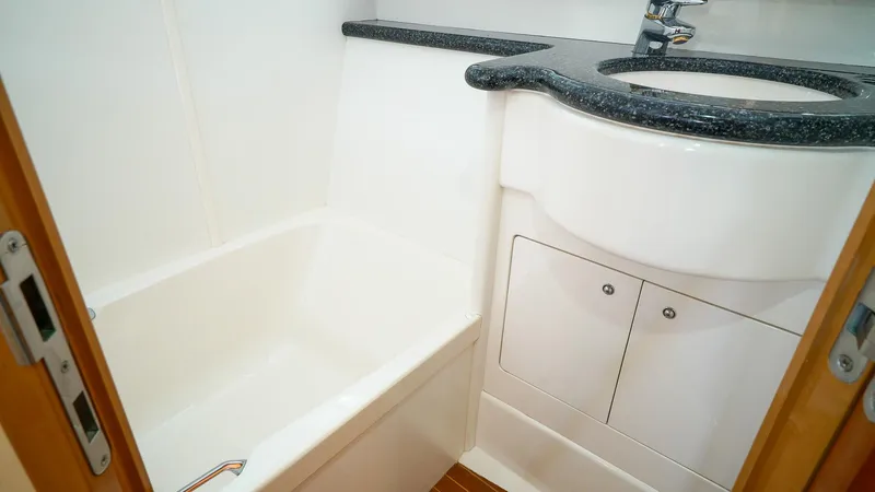 Slide: The Image of Luxurious bathroom in 2002 Viking Princess 68 yacht with sleek sink and compact bathtub. - 45