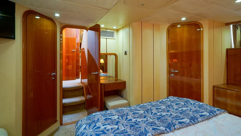 Slide: The Image of Luxurious cabin interior of 2002 Viking Princess 68 Sport Cruiser with wood finishes and blue bedding. - 49