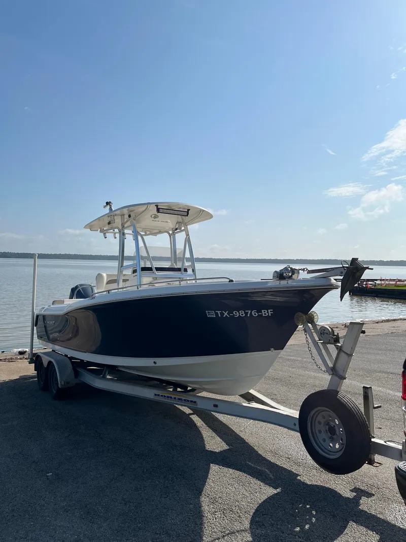 Slide: The Image of 2011 Sea Hunt Ultra 232 boat on trailer by the water under clear sky. - 1