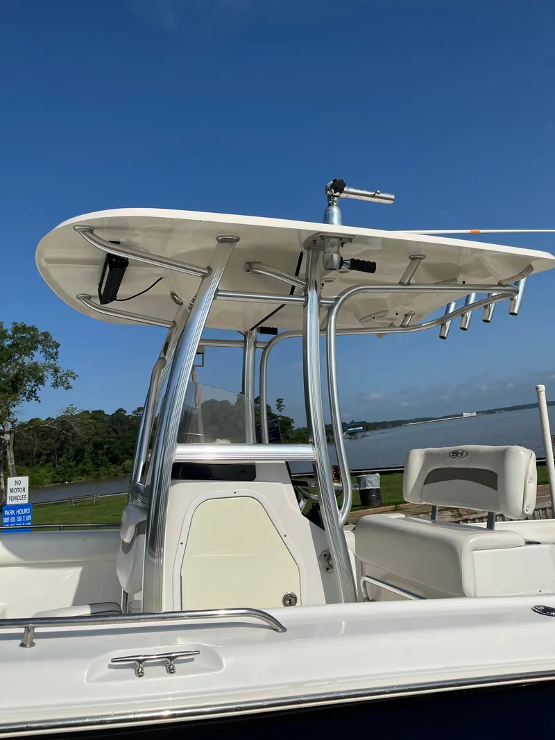 Slide: The Image of 2011 Sea Hunt Ultra 232 boat with T-top, docked by a scenic waterfront. - 11