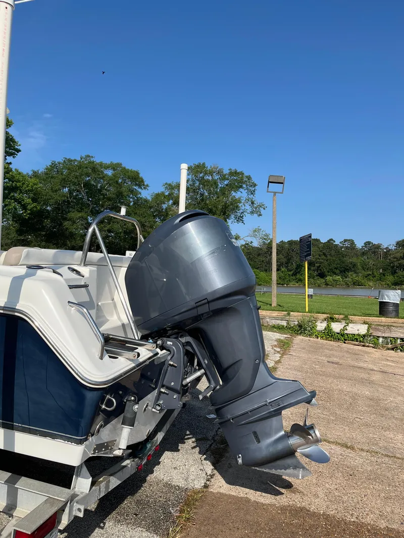 Slide: The Image of 2011 Sea Hunt Ultra 232 boat with outboard motor, parked on a sunny day. - 13