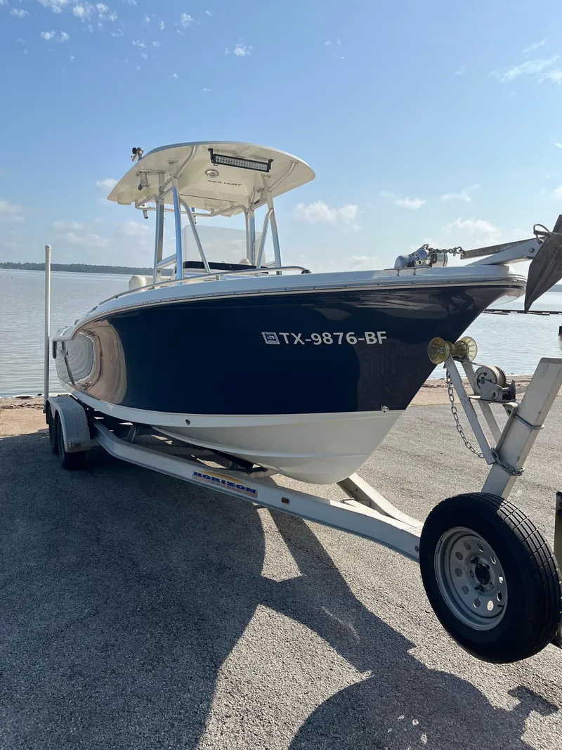 Slide: The Image of 2011 Sea Hunt Ultra 232 boat on trailer by the water under a clear sky. - 20
