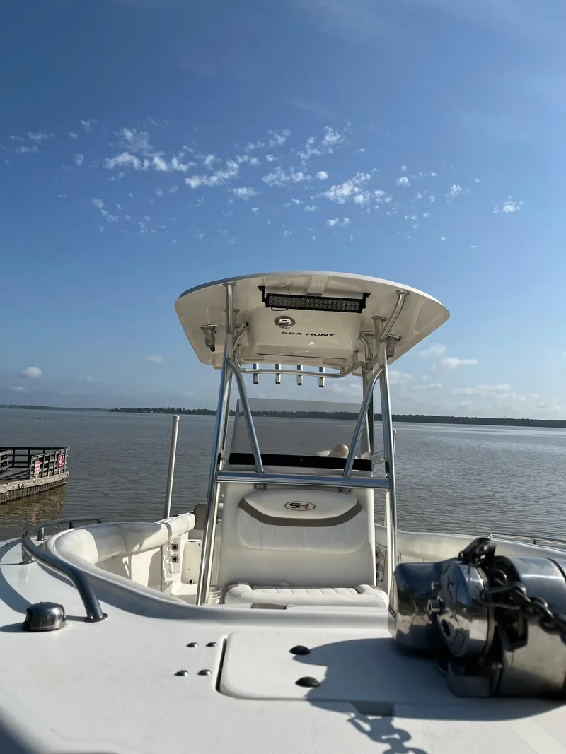 Slide: The Image of 2011 Sea Hunt Ultra 232 boat on calm water under clear blue sky. - 21