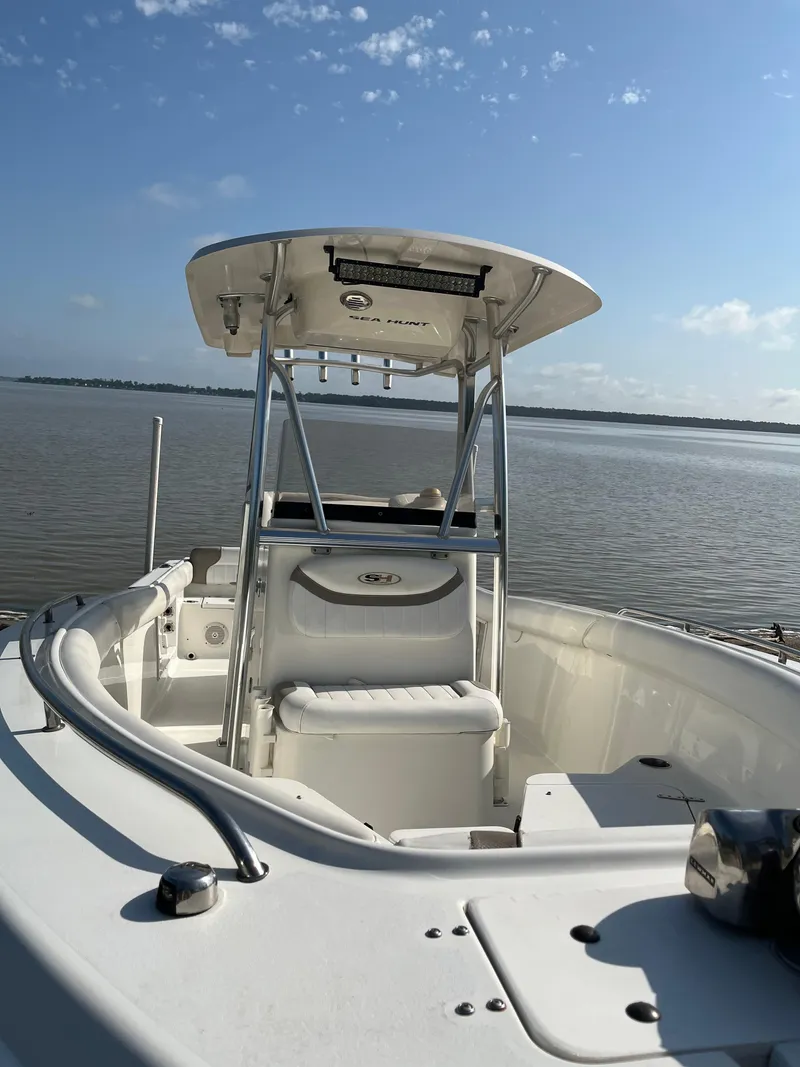 Slide: The Image of 2011 Sea Hunt Ultra 232 boat on calm water under clear blue sky. - 22