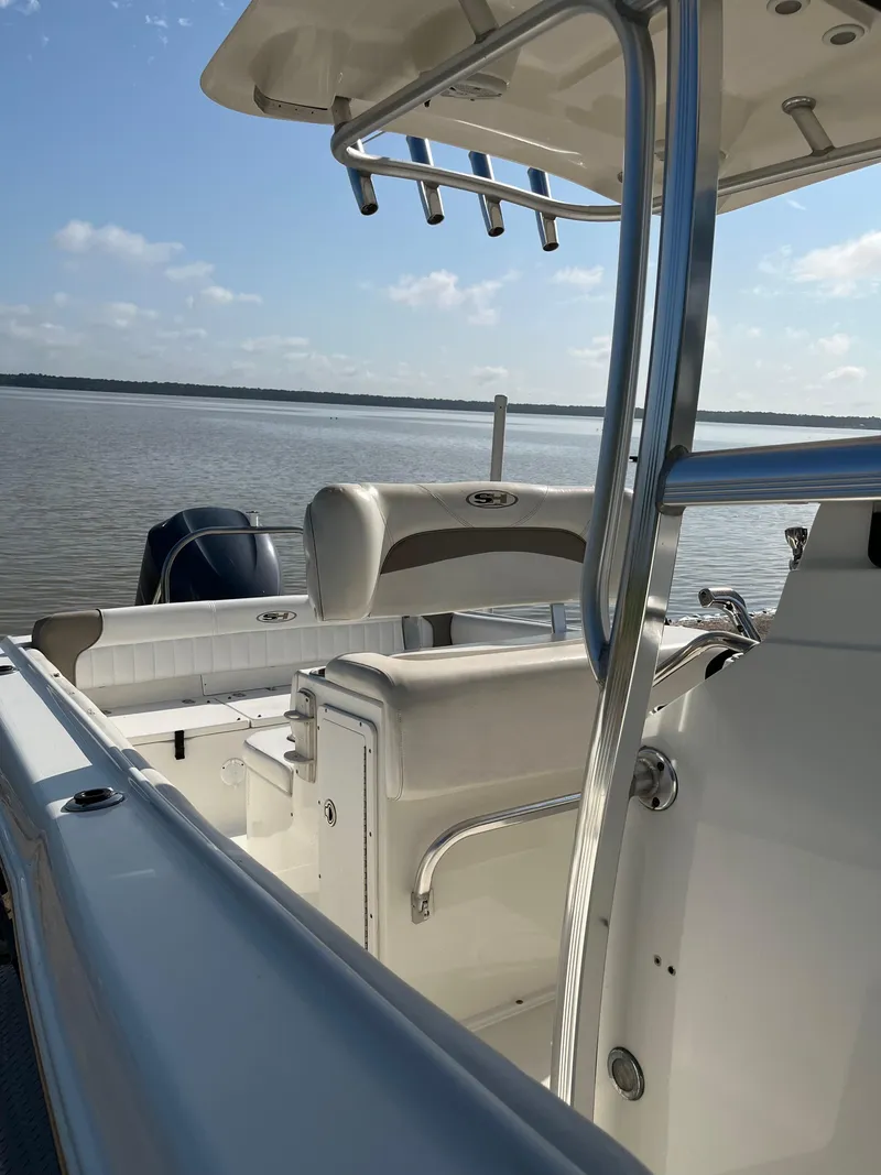 Slide: The Image of 2011 Sea Hunt Ultra 232 boat on calm water under a clear sky. - 23