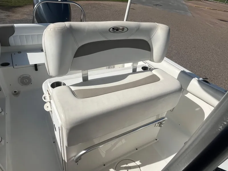 Slide: The Image of 2011 Sea Hunt Ultra 232 boat seat with white upholstery and cup holders. - 30