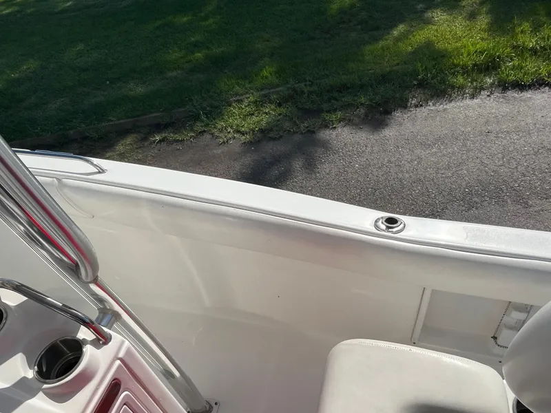 Slide: The Image of 2011 Sea Hunt Ultra 232 boat interior with seating and cup holder, parked on grass. - 32