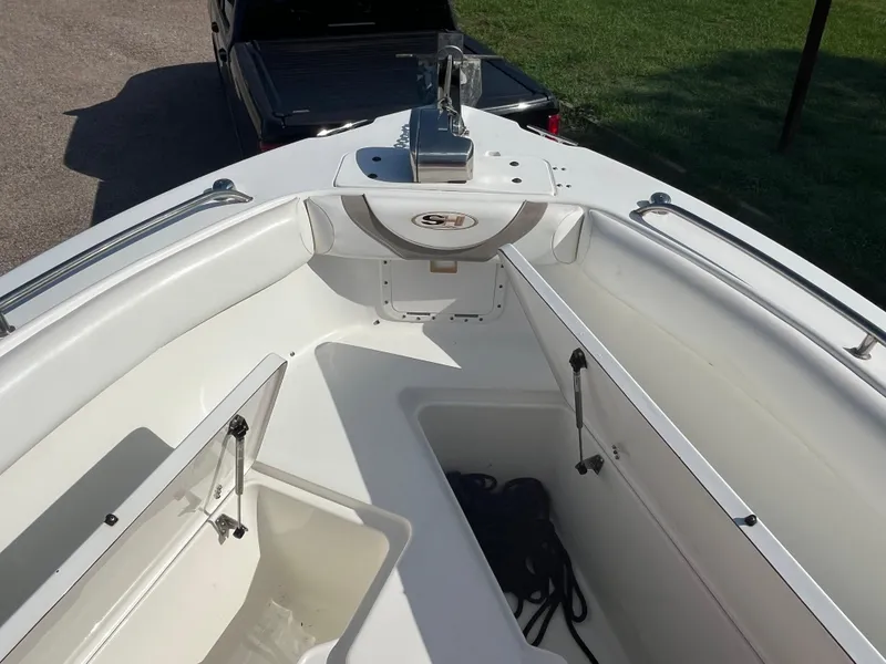 Slide: The Image of 2011 Sea Hunt Ultra 232 boat interior with storage compartments and anchor, parked on grass. - 38