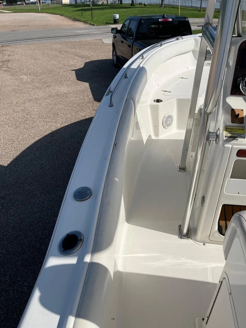 Slide: The Image of 2011 Sea Hunt Ultra 232 boat, white deck, parked near a vehicle. - 42