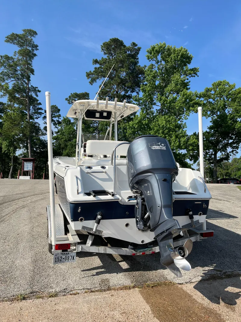 Slide: The Image of 2011 Sea Hunt Ultra 232 boat on trailer, parked outdoors with trees in background. - 6