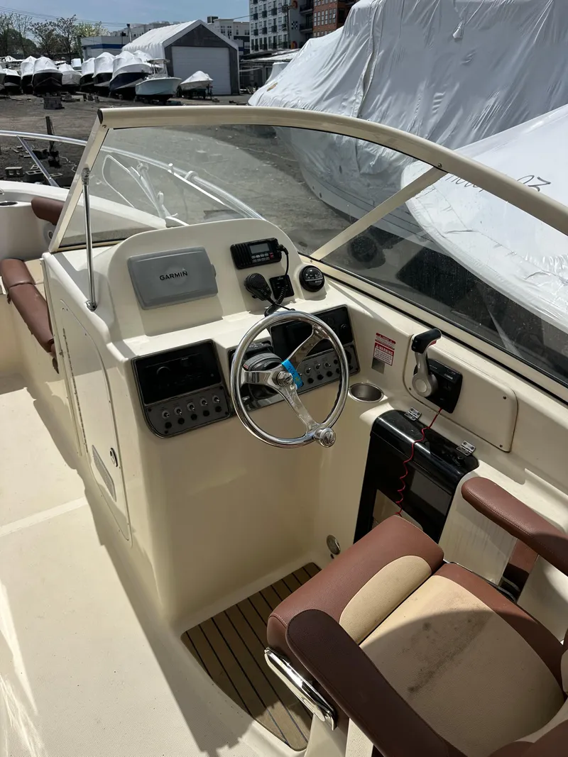Slide: The Image of 2014 Scout 245 Dorado boat cockpit with steering wheel and navigation equipment. - 11